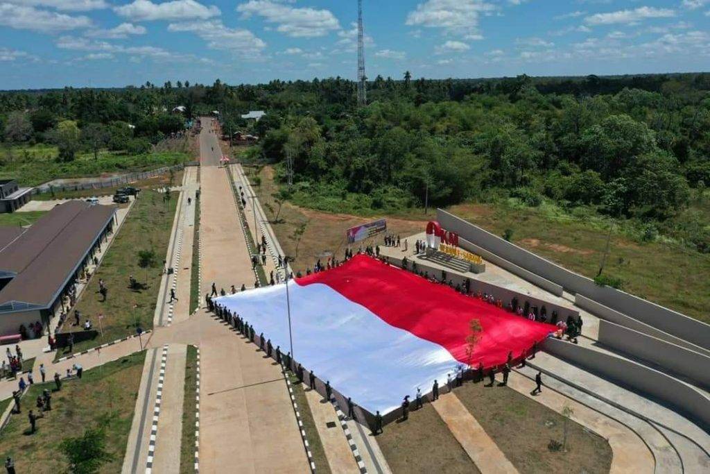 Korem 174 Merauke Bentangkan Bendera Merah Putih di Titik 0 Km PLBN Sota Merauke